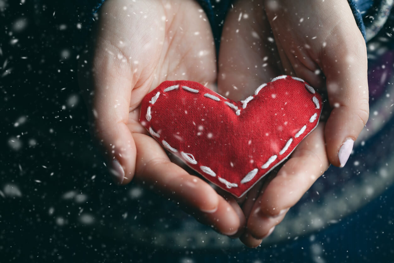 A woman's hands holding a soft stuffed heart